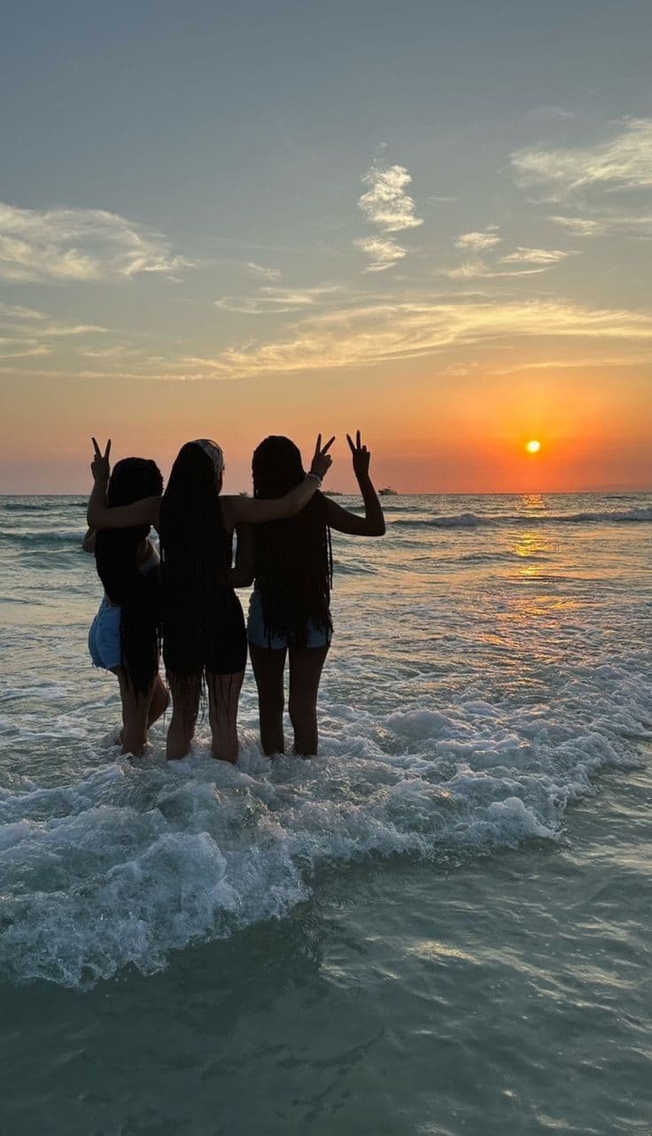 Women silhouetted against the sunset on the beach