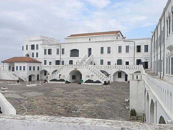 Cape Coast Castle rising above the Atlantic shoreline