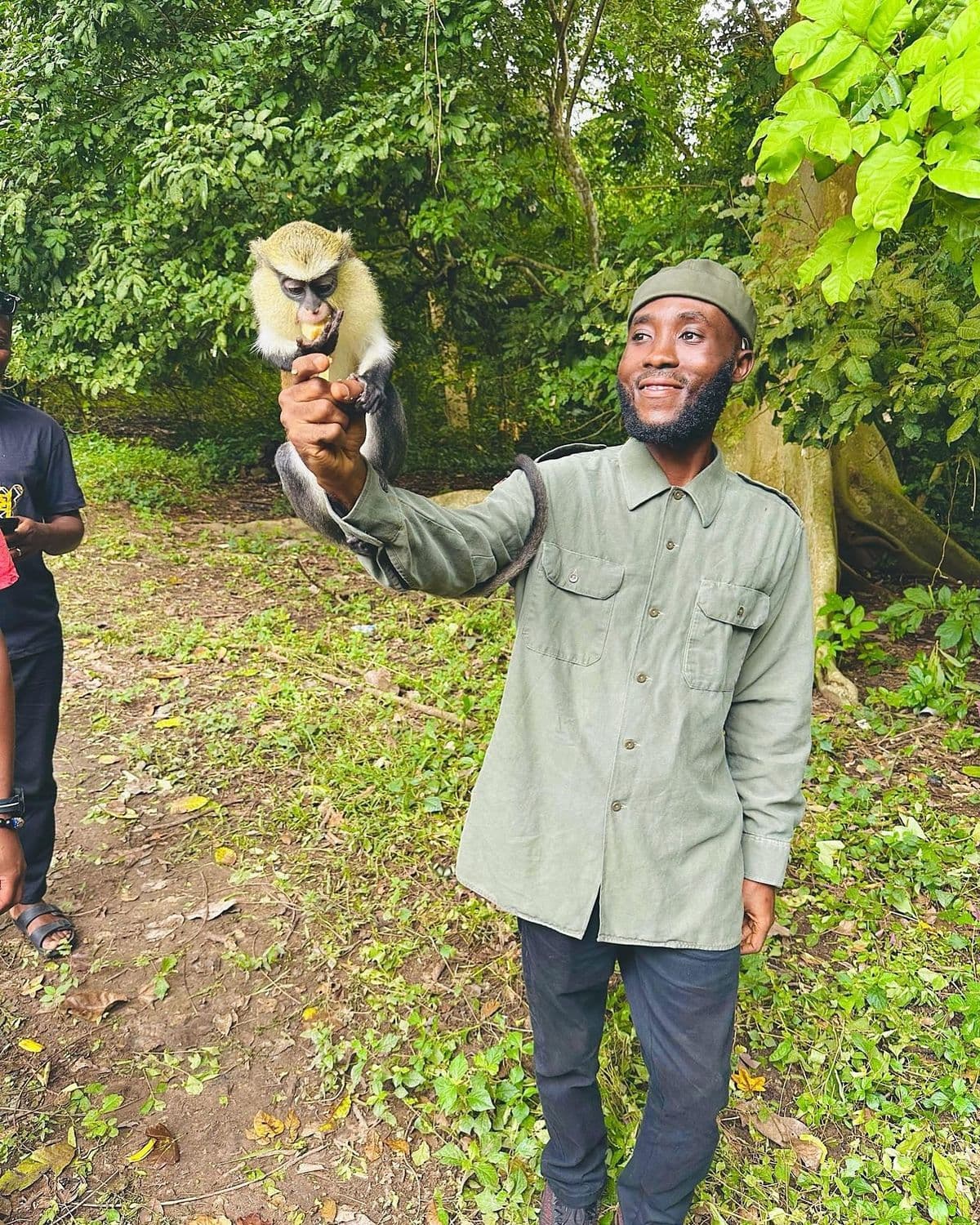 Guide feeding a monkey at Tafi Atome